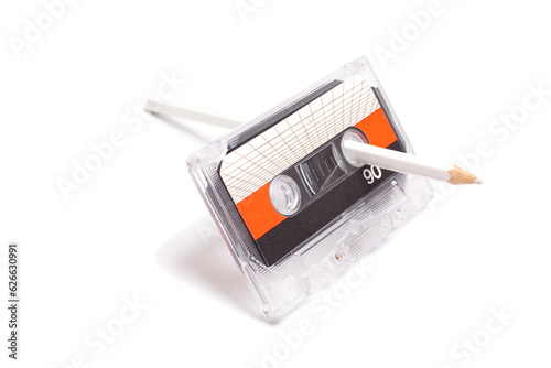 Audio cassette tape with pencil isolated on white background, vintage 80's music concept