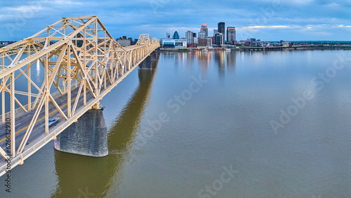 Panorama Ohio River rose gold truss bridge spanning toward illuminated Louisville skyscrapers
