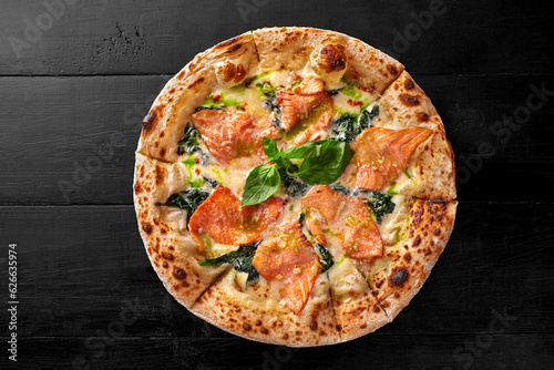 Pizza with cream cheese sauce, salmon, spinach, pesto and fresh basil
