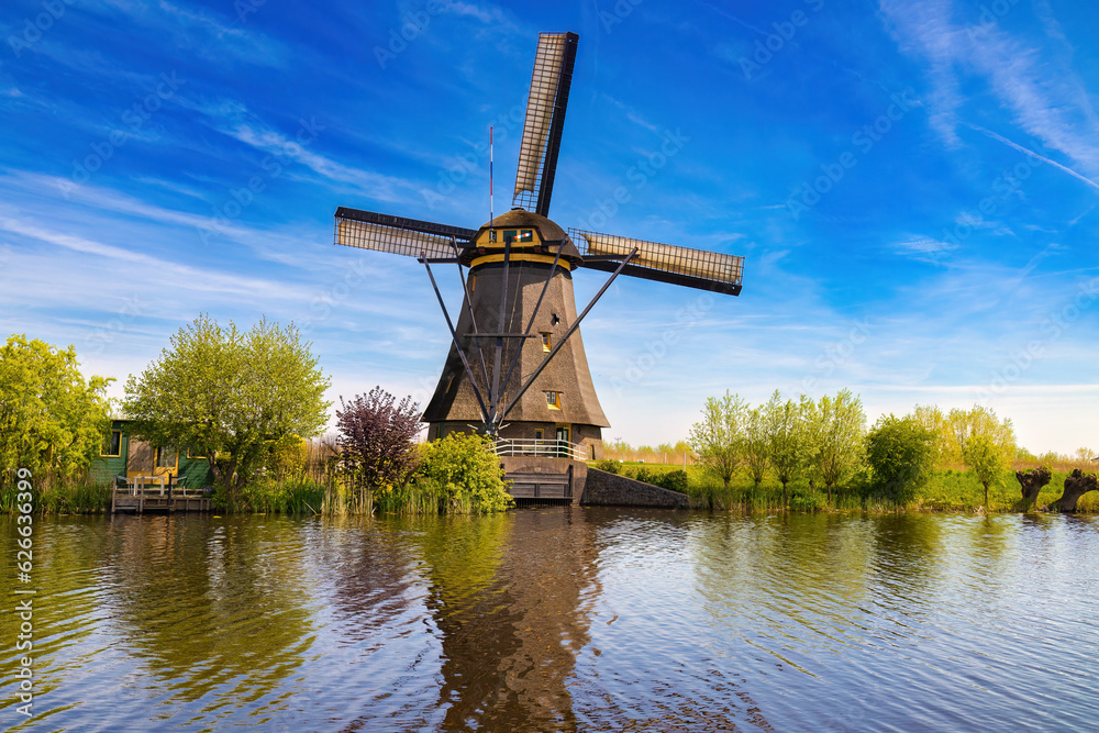 View of one of the huge Kinderdijk windmills, which is responsible for emptying the water from the pastures and emptying it into the canal. Netherlands. View of one of the huge Kinderdijk windmills, which is responsible for emptying the water from the pastures and emptying it into the canal. Netherlands.