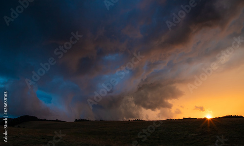 Landscape with sunset and dark storm clouds