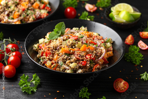 Red and white quinoa tabbouleh salad with tomatoes, paprika and mint. Vegetarian, vegan food concept photo