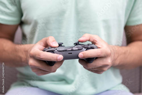 Man plays video games. Close-up of male hands holds joystick. Leisure time and gamer concept