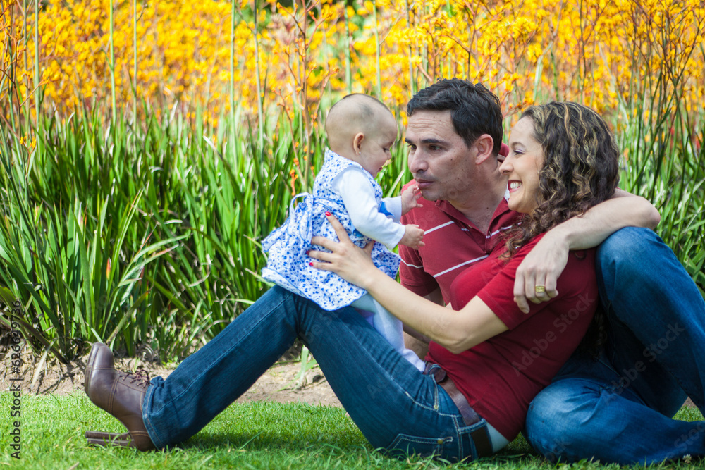 Young parents having fun outdoors with their six months old baby girl. Happiness concept. Family concept