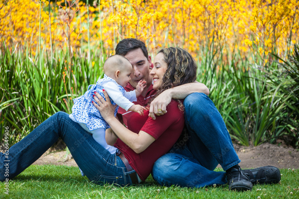 Young parents having fun outdoors with their six months old baby girl. Happiness concept. Family concept Young parents having fun outdoors with their six months old baby girl. Happiness concept. Family concept