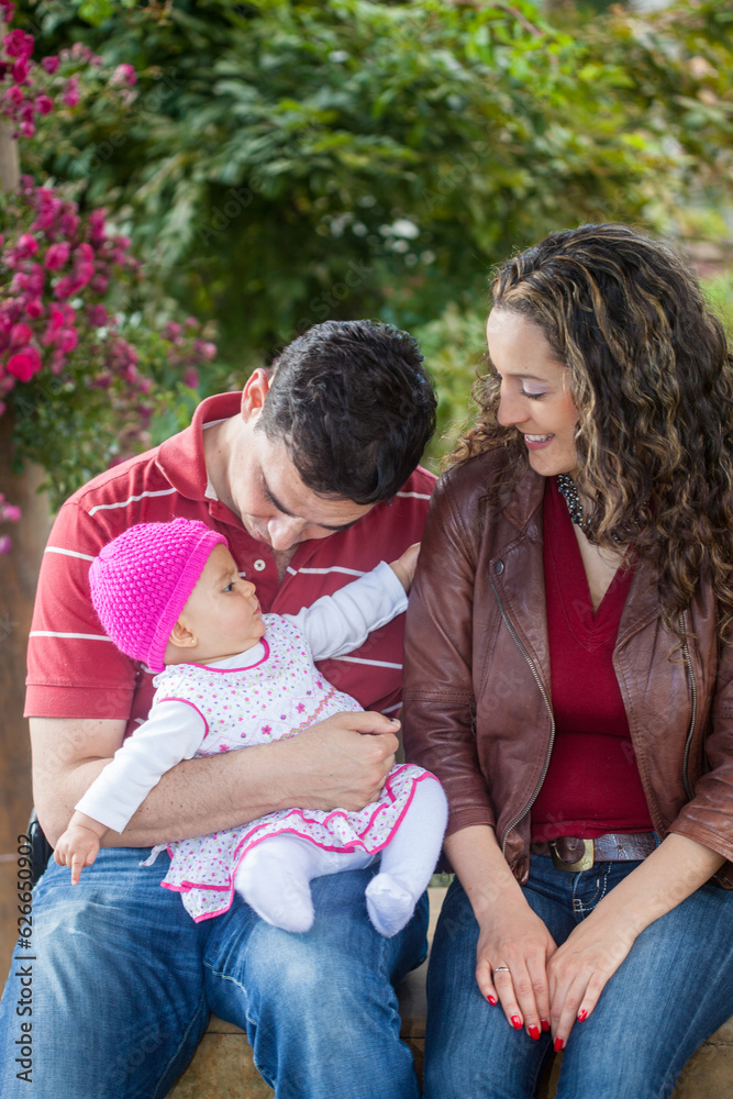 Young parents having fun outdoors with their six months old baby girl. Happiness concept. Family concept Young parents having fun outdoors with their six months old baby girl. Happiness concept. Family concept