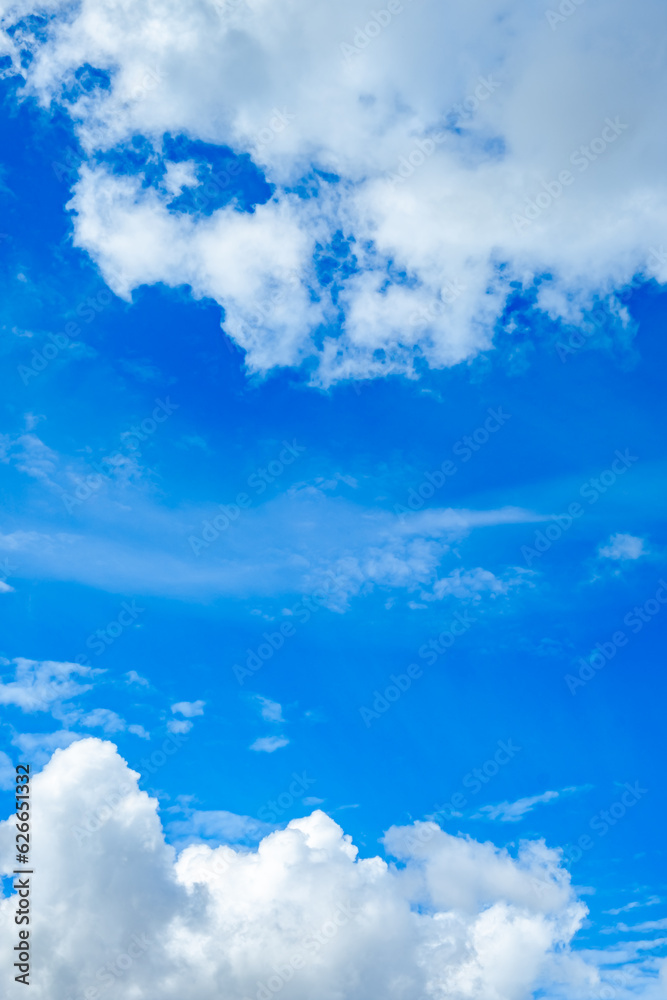 Cloudscape. Blue sky with white cumulus clouds in the noon. Vertical cloudy wallpaper. Natural background. Up view. Beauty in nature. Copy space Cloudscape. Blue sky with white cumulus clouds in the noon. Vertical cloudy wallpaper. Natural background. Up view. Beauty in nature. Copy space