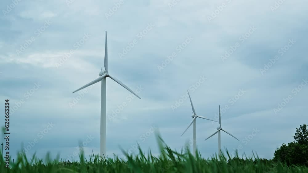 Green technology, clean and renewable energy solution concept. Wind power turbines generating alternative energy. Windmills farm. 4K, UHD Green technology, clean and renewable energy solution concept. Wind power turbines generating alternative energy. Windmills farm. 4K, UHD