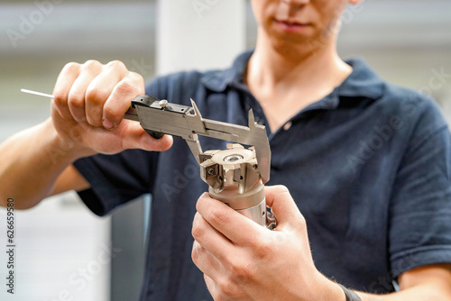 Measuring a cutting tool with a caliper for a CNC machine tool. photo