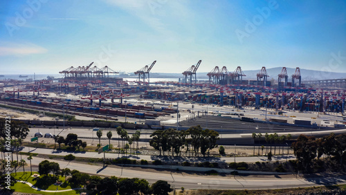 Rows of cargo containers rest atop massive container ships docked at an industrial port. Aerial view cargo ship terminal. Aerial view of shipping container port terminal. 