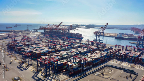 Obraz na płótnie Rows of cargo containers rest atop massive container ships docked at an industrial port. Aerial view cargo ship terminal. Aerial view of shipping container port terminal. w salonie