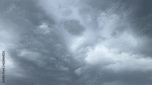 Stormy and rainy sky with cloudburst and natural abstract texture of clouds above the trees in summertime. Topics: weather, rainstorm, meteorology, climate, stormy season