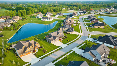 Aerial large ponds in rich expensive neighborhood with mini mansions, high-end, million-dollar homes