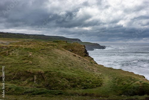 scenery of cliff walk, rough ocean on a cloudy day