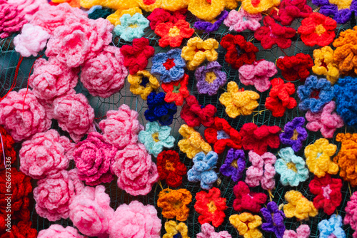 Beautiful colourful wool textile handmade flowers in a textured background still