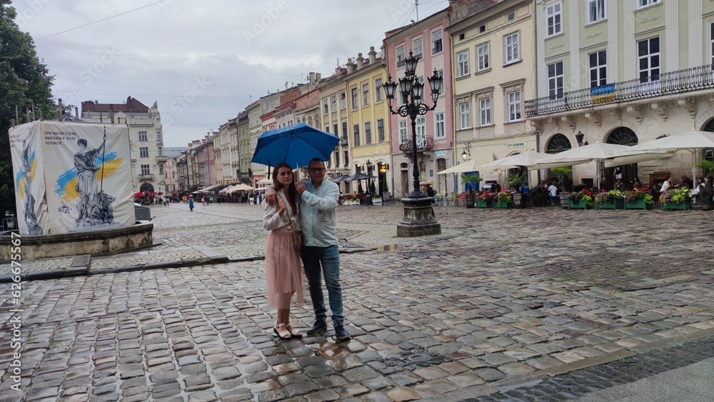 couple under an umbrella on the square of the city of Lviv Ukraine