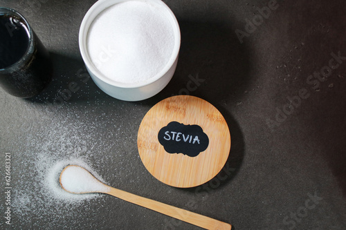 Top vie of a coke drink and natural stevia sweetener with s spoon, grey background