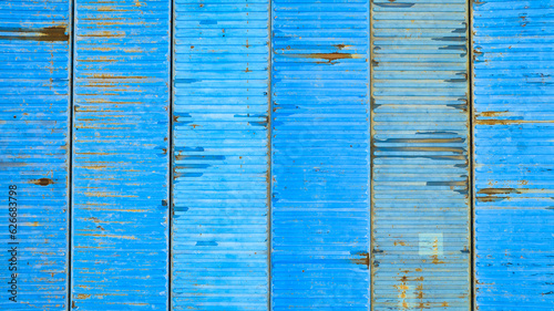 Six various blue pastel colored shipping containers from above, rusting metal crates background
