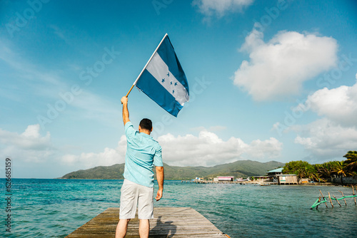 Man holding a honduras flag on Guanaja port.