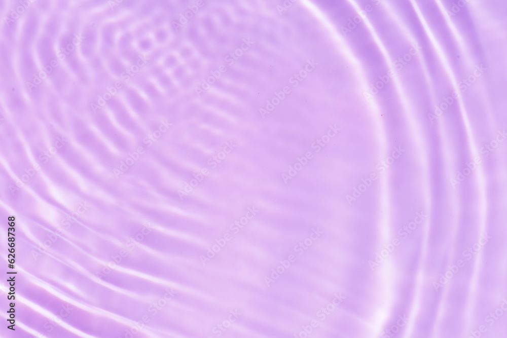 Obraz premium Purple water with ripples on the surface. Defocus blurred transparent pink colored clear calm water surface texture with splashes and bubbles. Water waves with shining pattern texture background.