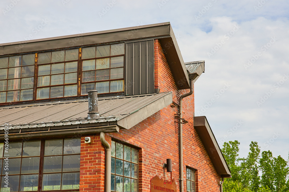 Abandoned glass factory with grimy windows and red brick exterior Abandoned glass factory with grimy windows and red brick exterior