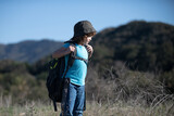 little boy with backpack hiking in scenic mountains. Boy local tourist goes on a local hike.