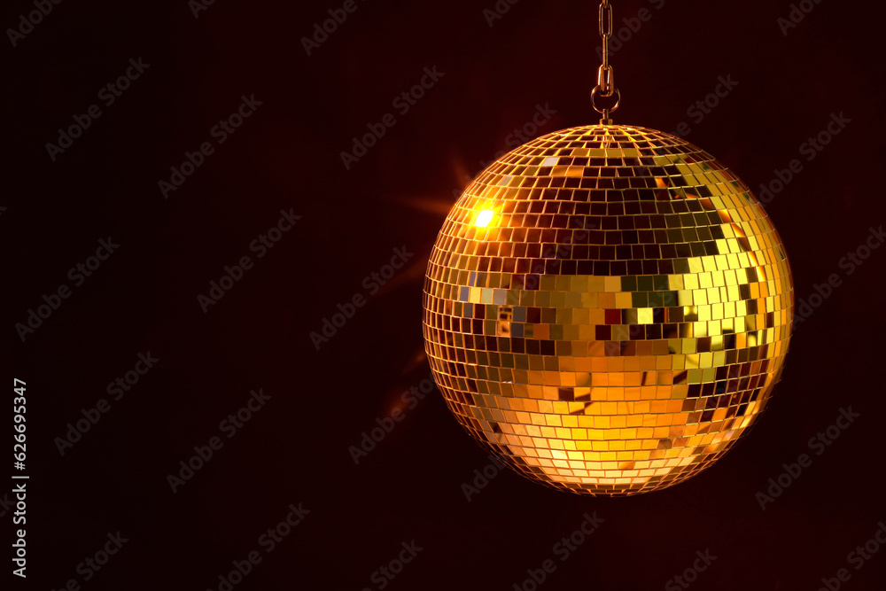 Obraz premium Shiny bright disco ball under orange light, space for text