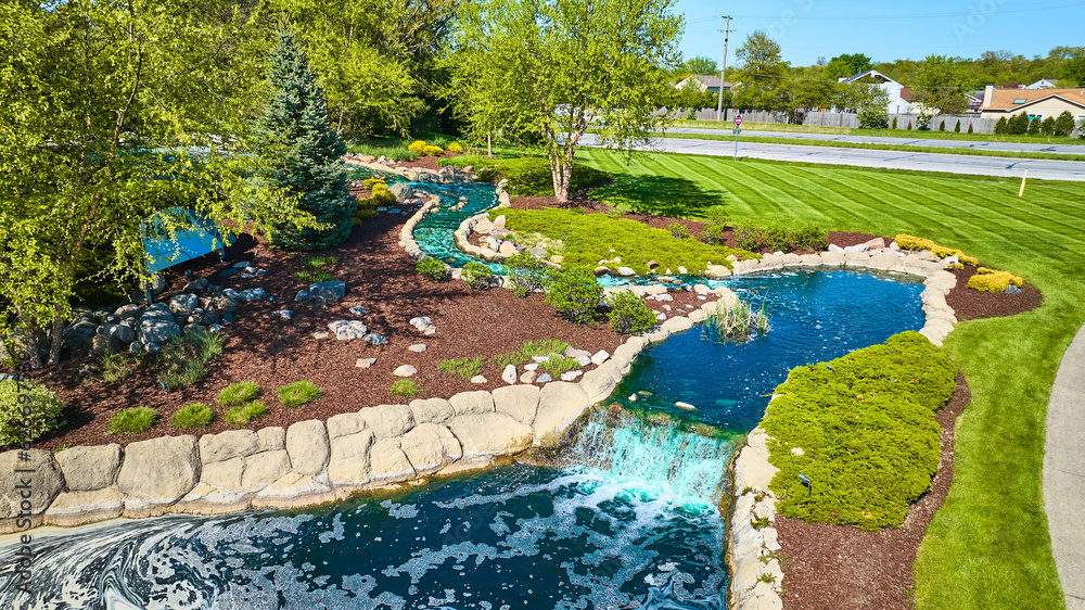 Blue creek river waterfall landscaping for neighborhood entrance professional cross cut of grass