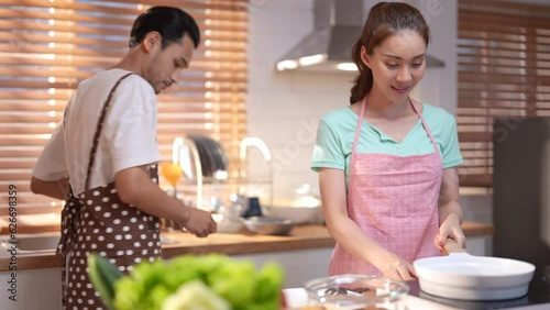 Asian couple feel happy and enjoy cooking together in home kitchen.