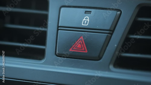 Driver Pressing to Warning Button On The Car With Her Finger at the Moment of Trouble. Turning On Emergency Signal to Warn Other Drivers for Prevent to Sudden Accident Macro Shot of Inside Car Part