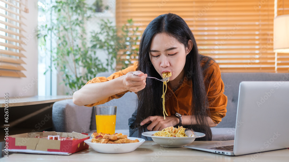Young Asian woman eating delicious spaghetti, enjoying tasty homemade lunch. Young Asian woman eating delicious spaghetti, enjoying tasty homemade lunch.