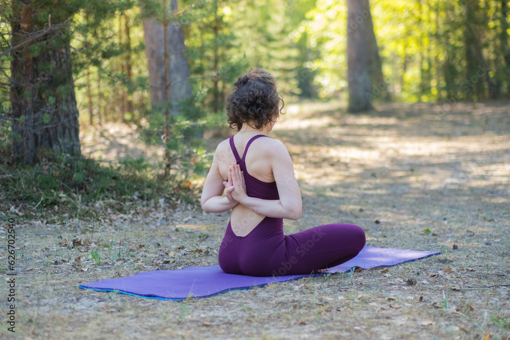 Young woman doing yoga outdoors in the park