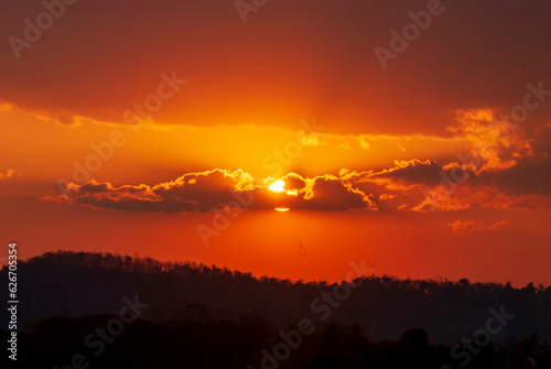 Scenic view dramatic beautiful sunset sky. Natural Sunset Sunrise on meadow silhouette shadow dark land. Vibrant dramatic sky on sunset, dawn, sunrise in Countryside. Landscape Colorful Sky At Sunset