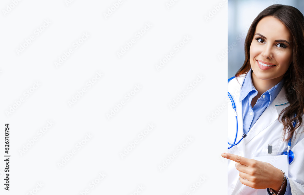 Portrait image of smiling female doctor pointing blank signboard with copy space empty area for some text, at office. Young brunette woman in medical, clinic, healthcare concept Portrait image of smiling female doctor pointing blank signboard with copy space empty area for some text, at office. Young brunette woman in medical, clinic, healthcare concept