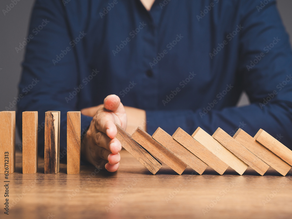 Business professionals stop the crisis domino effect, safeguarding against business collapse. Stock Photo | Adobe Stock Business... 