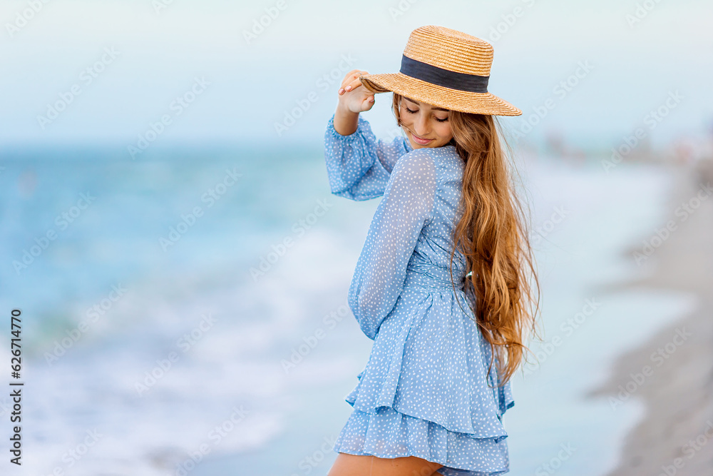 Beautiful teenager girl on tropical seashore at sunset. Beautiful little girl in dress at beach having fun. Happy girl enjoy summer vacation background the blue sky and turquoise water in the sea