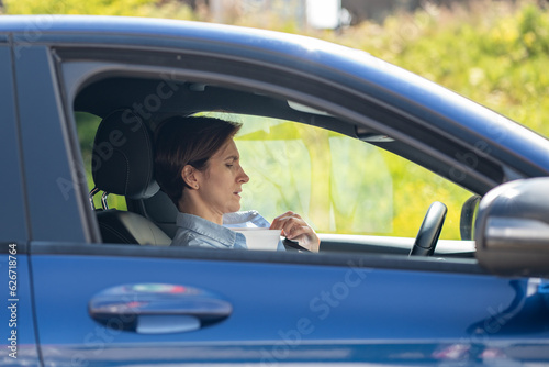 Woman drives car with broken air conditioner in hot summer weather. Middle aged female suffering from heat stuffiness. Tired exhausted overheated stressed worried driver trying to refresh her body. © DimaBerlin