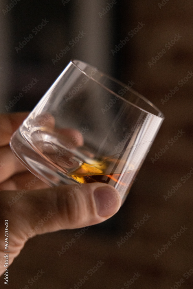 Man holding a glass of Scotch, doing a Whisky tasting Man holding a glass of Scotch, doing a Whisky tasting