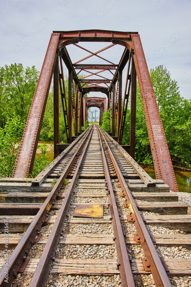 Vertical shot of iron train bridge with railroad tracks over Kokosing River