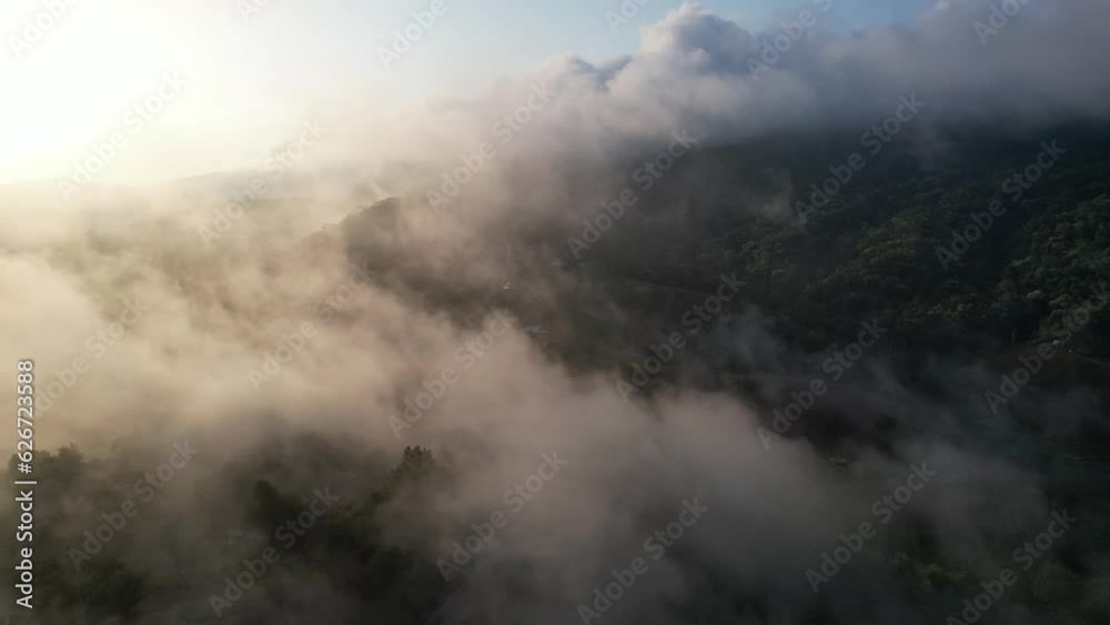 Aerial landscape view of greenery hills and the car running on mountain road on foggy day by drone Aerial landscape view of greenery hills and the car running on mountain road on foggy day by drone