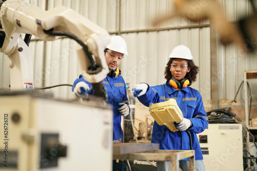 Multiracial industrial engineers working at automated AI robotic production factory, New industrial technology concept.