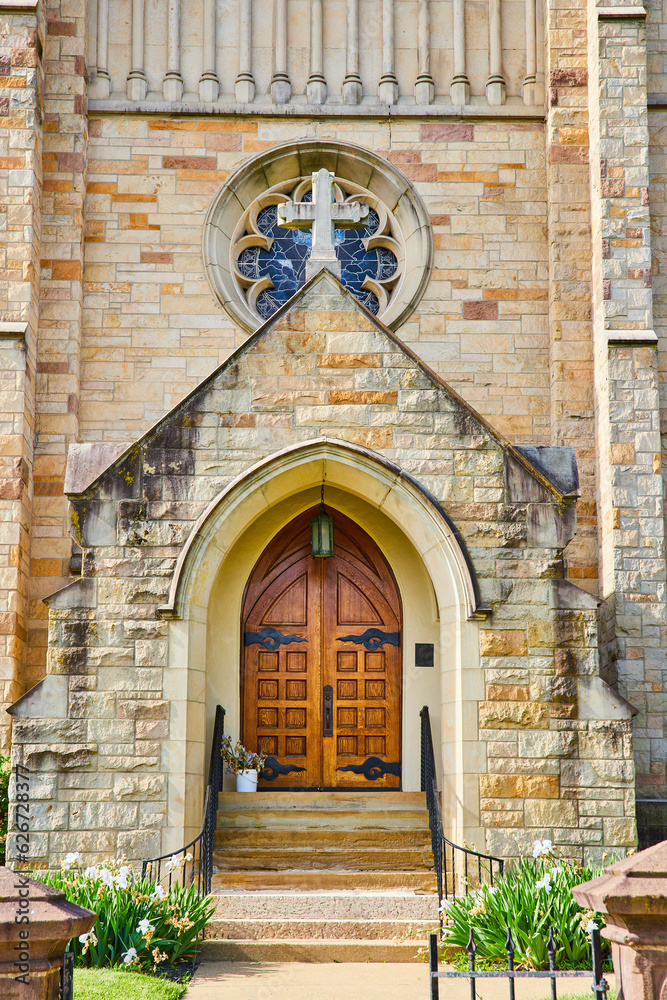 Front entrance to St. Pauls Episcopal Church with heavy oak doors and cross and stained glass