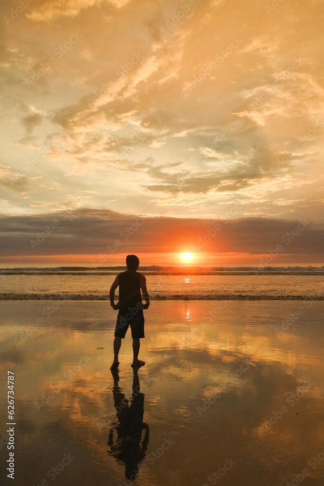 A man enjoy beautiful sunset at Seminyak beach in Bali, Indonesia.