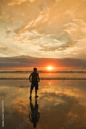A man enjoy beautiful sunset at Seminyak beach in Bali, Indonesia.