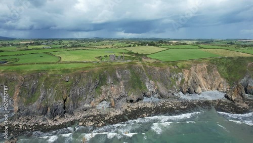 Summer storm waves pound the Copper Coast at Tankardstown with moody rain laiden clouds approaching bringing heavy showers on a July morning photo