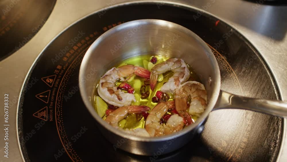 Preparing traditional Mediterranean seafood shrimp soup in a pot inside a professional restaurant kitchen 