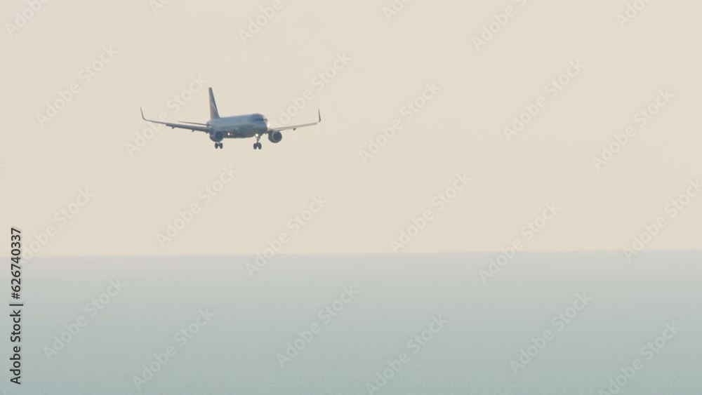 Jet airplane approaching to land at Adler airport, Sochi. Long shot of aircraft descending. Tourism and travel concept Jet airplane approaching to land at Adler airport, Sochi. Long shot of aircraft descending. Tourism and travel concept