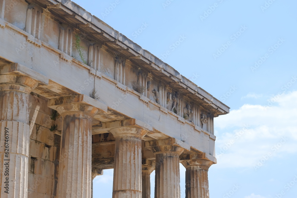 Old ancient restored Greek building with columns and roof in ancient Athens museum on a blue sunny sky, Greece