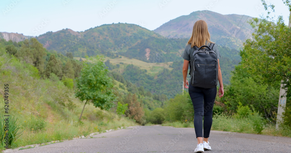 Young woman walks in the mountains and admires the beautiful landscape