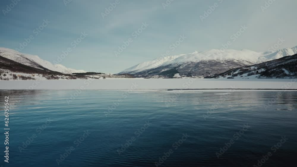 Arctic Fjord Glacier in Norway outside Tromso. Clear Sunny Blue Sky. Snowy Mountains. Wide Shot. Slow Motion. Arctic Fjord Glacier in Norway outside Tromso. Clear Sunny Blue Sky. Snowy Mountains. Wide Shot. Slow Motion.